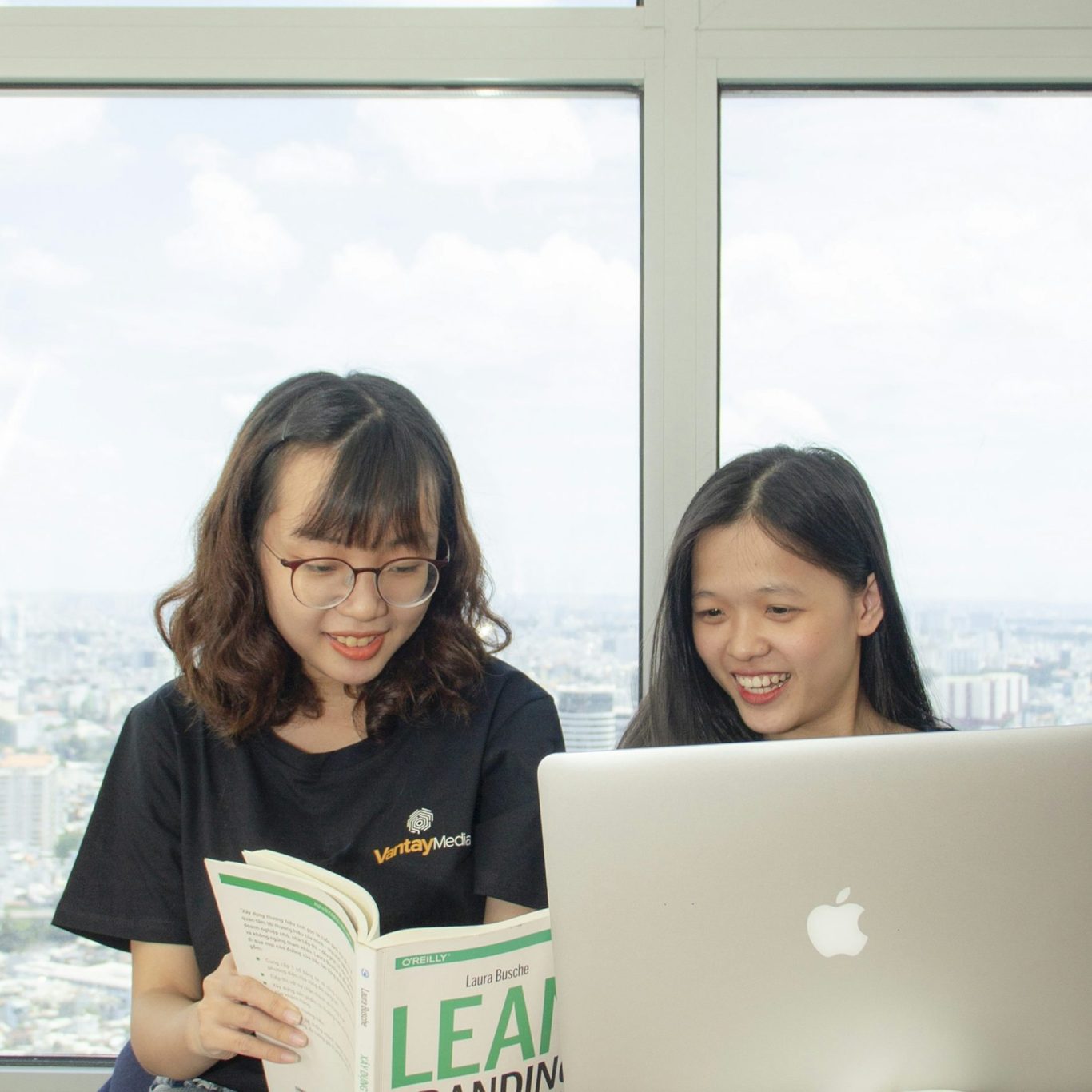 picture of two people reading a book and working on a computer